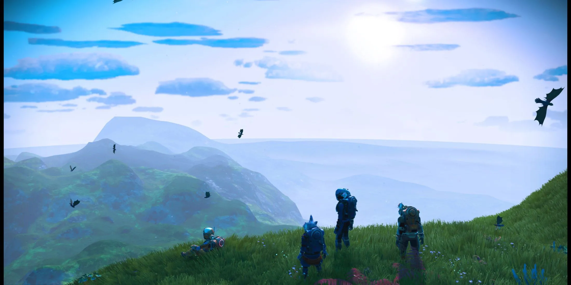 Nhóm người chơi No Man's Sky khám phá địa hình đồi núi hiểm trở, thể hiện yếu tố khám phá và tương tác cộng đồng.