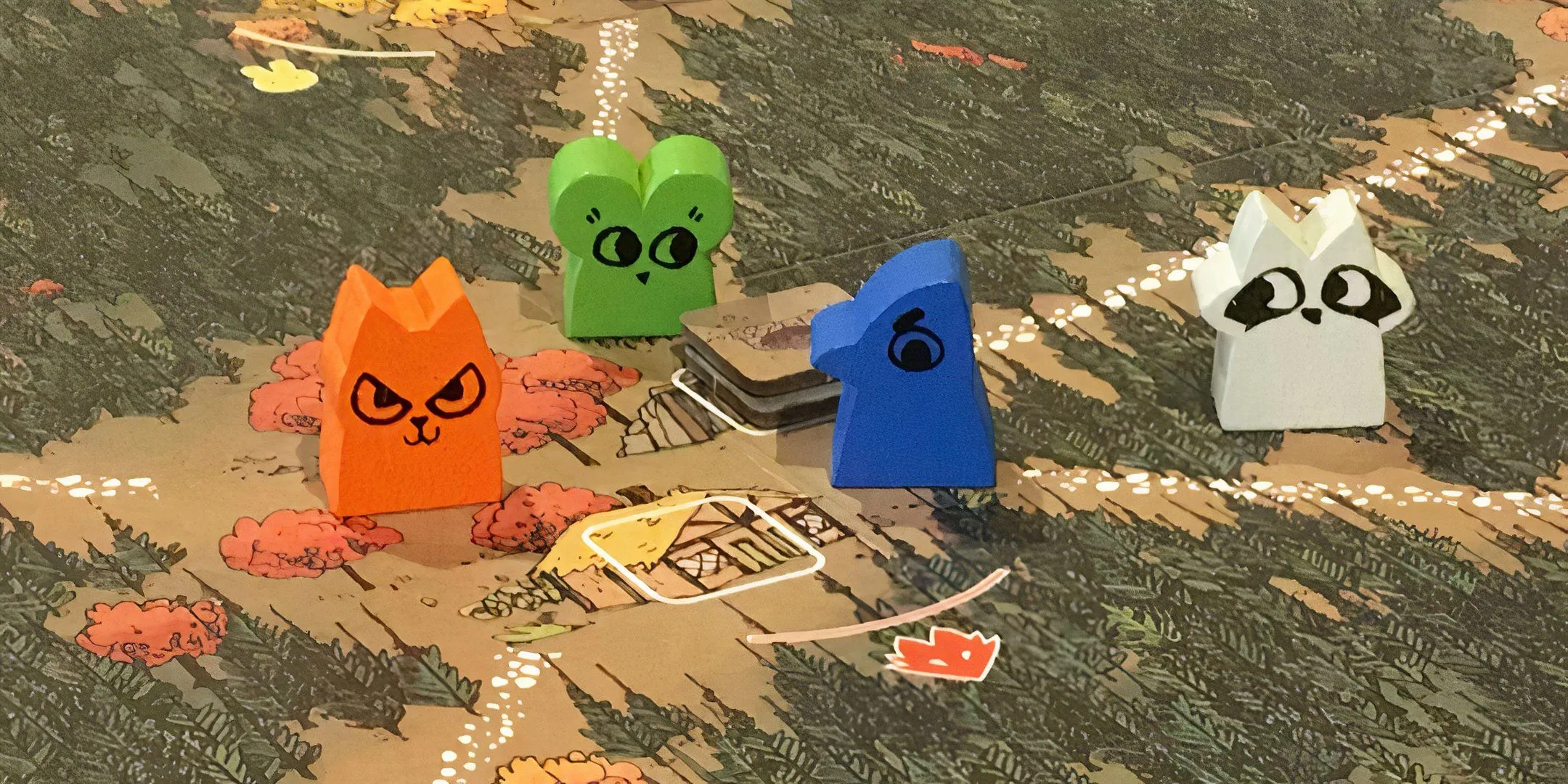 Bốn quân cờ gỗ Root trên bản đồ board game Root.