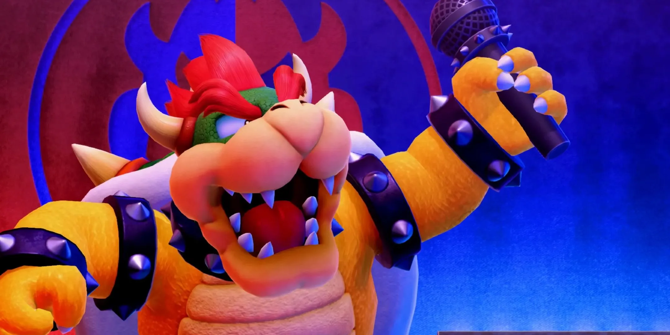 Bowser trên sân khấu với micro trong tay.