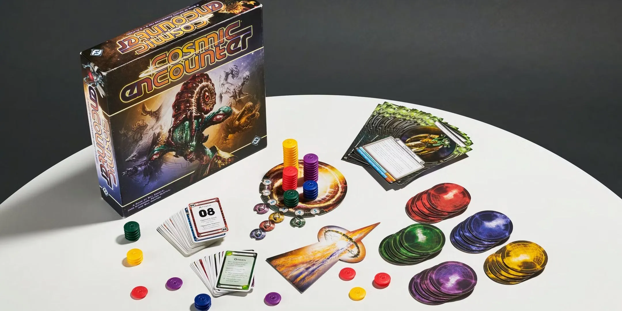 Các quân cờ và hộp trò chơi board game Cosmic Encounter được sắp xếp trên bàn.