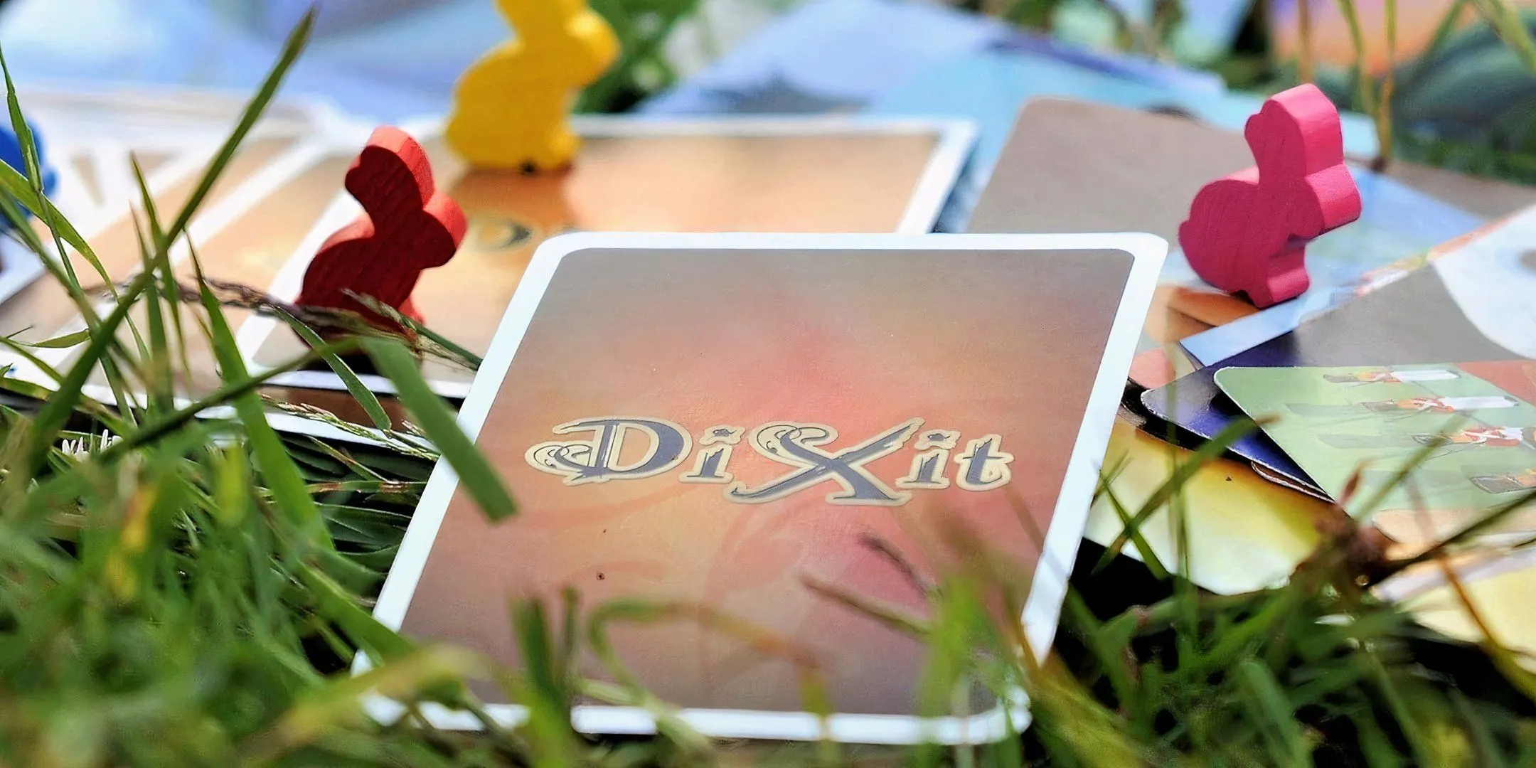 Hình ảnh bìa hộp và các lá bài minh họa nghệ thuật của board game Dixit, một game kể chuyện sáng tạo
