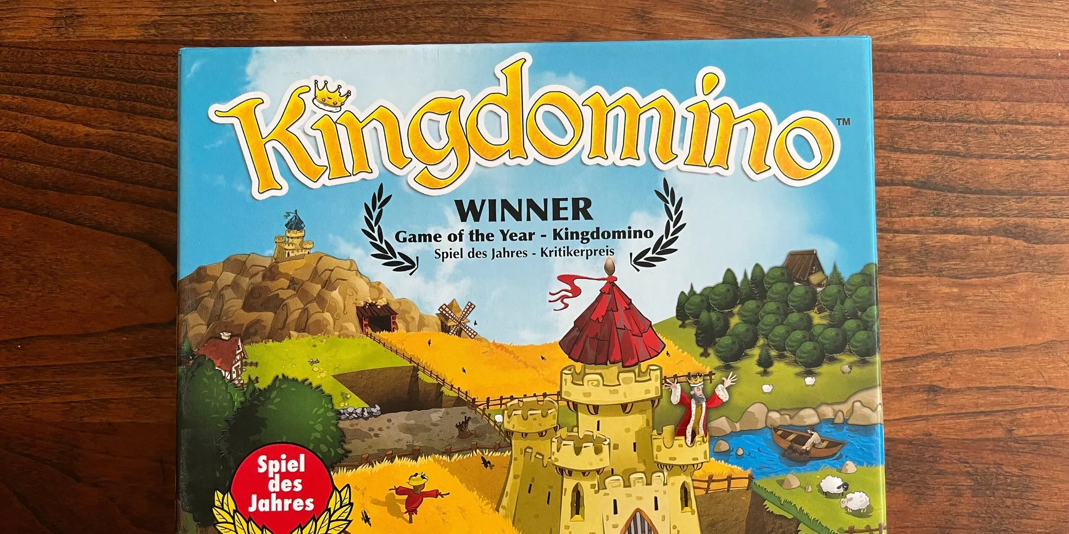 Mô tả hình ảnh: Hộp bìa của board game King Domino, thể hiện hình ảnh lâu đài và các mảnh ghép địa hình như domino.