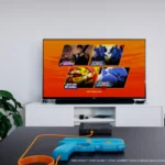 Súng G'aim'e Plug & Play màu xanh trước màn hình TV hiện đại trình chiếu game Time Crisis